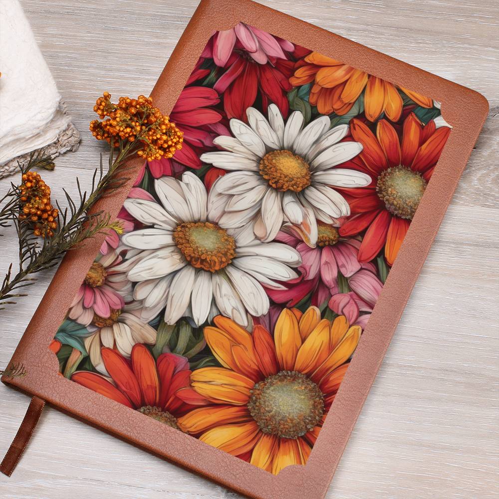 Colorful daisies on a vegan leather journal on a wooden surface.