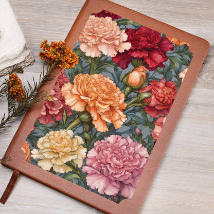 Colorful carnations on a vegan leather journal on a wooden surface.
